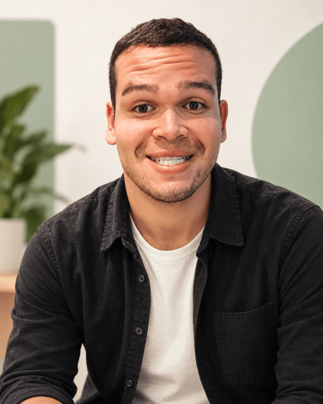 Retrato de Cadu Dantas sorrindo, em pose natural.